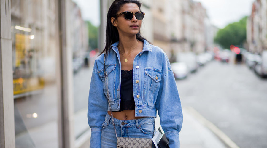 LONDON, ENGLAND - JUNE 09: A guest wearing a Gucci bag, denim jacket, denim jeans, cropped top during the London Fashion Week Men's June 2017 collections on June 9, 2017 in London, England. (Photo by Christian Vierig/Getty Images)